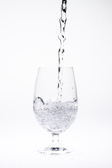 Pour water in glass isolated on white background.