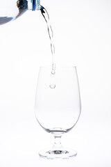 Pour water in glass isolated on white background.