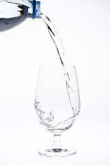 Pour water in glass isolated on white background.