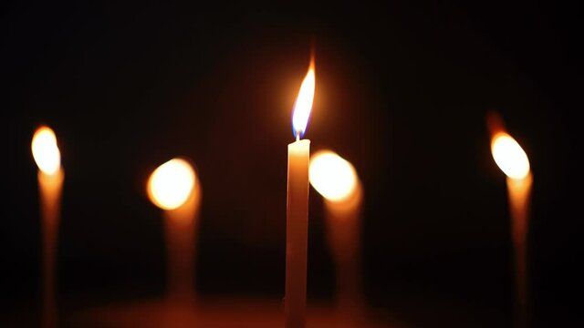 Footage of light from candles in the dark and bokeh of candles