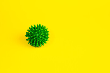 COVID-19 on a yellow background. New coronavirus infections. Image of a green coronavirus. Coronavirus and empty space for inserting text. Copy space.