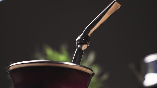 Close up Calabash Argentinean Mate (Mate Argentino). Traditional herbal infusion beverage common in Argentina, Uruguay, Paraguay and Brazil. Panning around shot