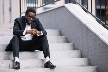 Businessman sit at office staircase.