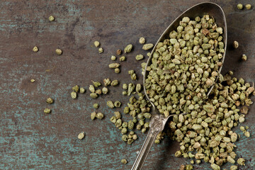 Organic Heap of dried thyme seeds in an old metal spoon on a grunge background. Spices on a dark...