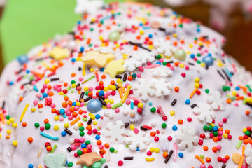 sugar glazed icing cake coating, decorated with colored candy sweets close up background