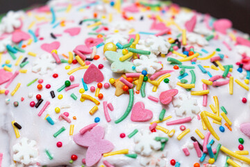 sugar glazed icing cake coating, decorated with colored candy sweets close up background