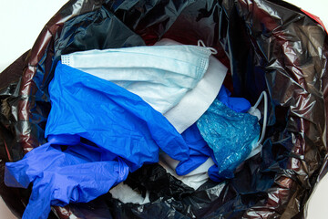 thrown out, discarded medical gloves and protective masks in the trash bin after quarantine
