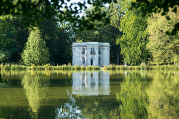 Old house on the lake. Reflections of a building in the water on a bright summer day