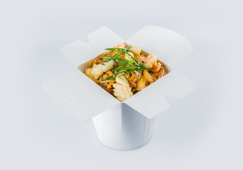 Isolated Food delivery box with ready meals inside. Asian Seafood Harusame rice Noodles with shrimp, mussels, calamari, scallop, vegetables and spring onion scallions in white carton takeaway package
