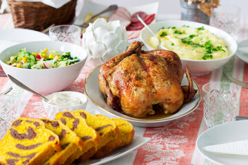 Homemade holiday dinner with baked chicken, mashed potatoes, salad, snacks and dessert.
