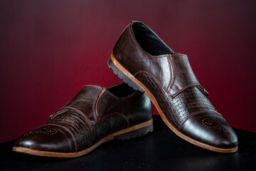 Brown leather men's shoes on red background
