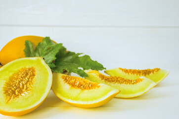 whole melons, halves and slices of melon on a white background close-up. background with fresh melons on the table.
