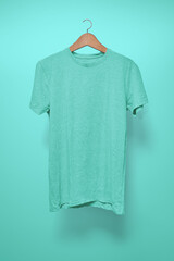 Turquoise T-Shirt on a hanger against a turquoise background
