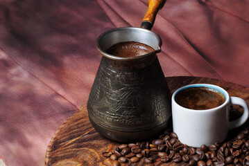 Coffee in cezve and white cup on a red background