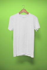 White T-Shirt on a hanger against a green background