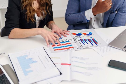 Successful young mixed race work team analysing financial report during their work under joint project at the boardroom table. Business and financial concept.