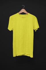 Yellow T-Shirt on a hanger against a black background