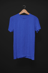 Dark blue T-Shirt on a hanger against a black background
