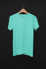 Turquoise T-Shirt on a hanger against a black background