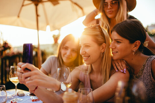 Three young woman at restaurant taking selfie
