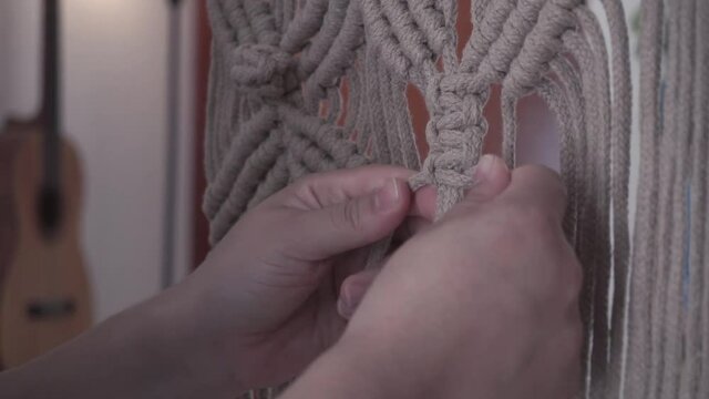 manos tejiendo nudos para un hermoso macram&eacute;