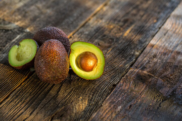 Avocados on wooden table. Avocado in bowl. Raw fresh cut avocados.