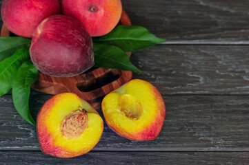 background with peaches close-up. peaches in a wooden bowl on a wooden background and a copy of the space.whole peaches and half peaches on the table.