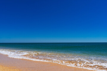 the azure turquoise sea with yellow sand from shells.