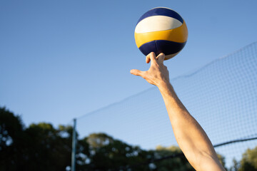 volleyball ball in the air and the hand hits it