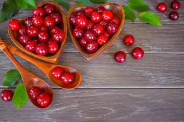 ripe cherries in wooden bowls and spoons top view. background with cherry berries close-up.