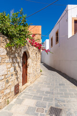Beautiful Greek street with summer flowers in Lindos village. Rhodes island. Greece.