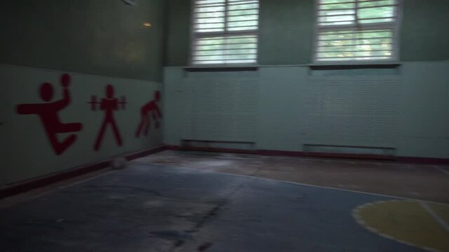 the camera moves along the corridor of the school. Explore an empty gym building destroyed by an earthquake. Interior of an abandoned house, post-apocalyptic ruins.