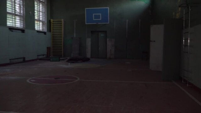 the camera moves along the corridor of the school. Explore an empty gym building destroyed by an earthquake. Interior of an abandoned house, post-apocalyptic ruins.