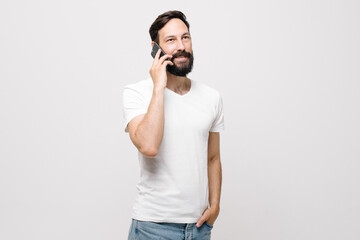 Portrait of happy young man smiling and using cellphone