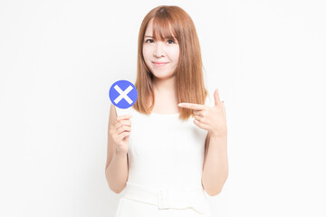 バツのプラカードを持つ若い女性