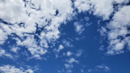 Blue sky with a lot of clouds on it. Blue background with sky for your design. Cloud on top with more blue on the bottom.