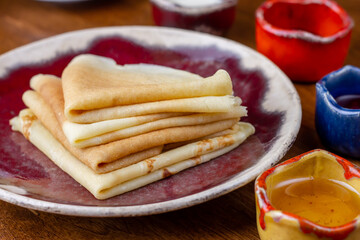 Pancake breakfast for tea. Homemade pancakes with honey on wood background. Delicious, healthy, tasty food. Holidays, recipe concept.