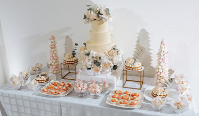 Candy bar at the banquet. Wedding table with sweets, cake, pastries, muffins, sugar treats. Event in the restaurant