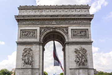 Fototapeta na wymiar Arc de Triomphe de l'Etoile (1806 - 1836) decorated with the flag of France on French National Day (Bastille Day). Paris, France.