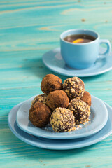 A portion of homemade energy balls and a Cup of tea on a blue wooden table. Delicious, healthy dessert. Lifestyle. Diet. Close up