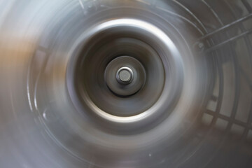 circle with a bolt head on the metal blades of a rotating fan.
