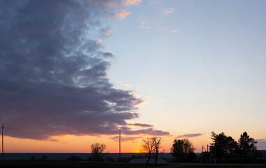 Landscape at sunset. Tragic gloomy sky. The village in the Budjak steppe. The terrain in southern Europe. Panorama. Crimson twilight.