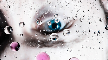 Blue eyes reflection in water droplets and glass surface macro background. Human connection and looking through window wallpaper