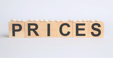 the inscription "price" on a background of wooden cubes with white pills, the concept of medicine, pharmacological business