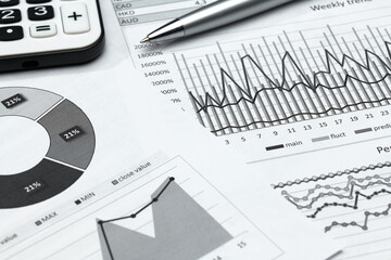 business office desk closeup - financial reports, analysis and accounting, set of documents, tables and graphs, various items for bookkeeping, calculator