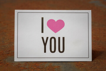 I Love You Printed Card Laying on The Rusty Metal Background