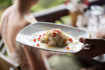 A waiter with a plate of salad. Millionaire Mauritius.