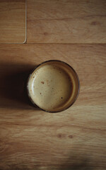 Glass with coffee with milk with white foam on a wooden background.