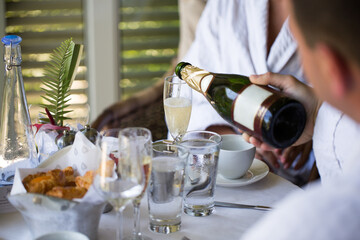 A man pours champagne in a glass