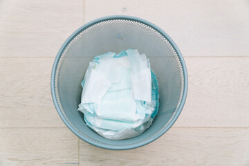 Disposing of used nappies in trash. Concept of child care